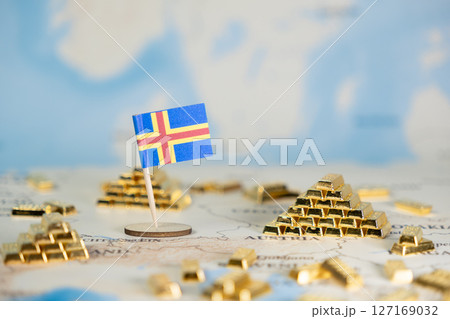Aland Islands flag on world map with stacked gold bars, symbolizing national wealth, global economic stability, and financial investment, offering ample copy space 127169032