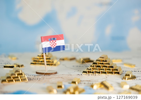 Croatian flag pin stands among gold bars on a map, symbolizing national wealth, economic stability, and global investment opportunity with clear copy space 127169039
