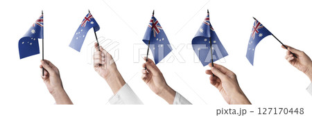 The Australia flag in hand in different angles on a white background 127170448