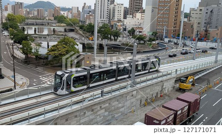 広島駅前大橋から広島駅ビル2階への斜面で試運転をする広島電鉄の路面電車 127171071
