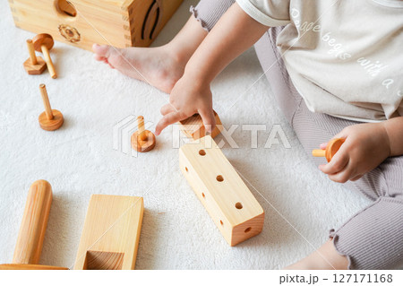 木のおもちゃで遊ぶ子どもの手元 127171168