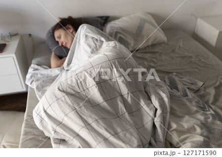 Woman sleeping peacefully in bed on a sunday morning Woman sleeping peacefully in bed on a sunday morning 127171590