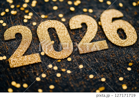 Gold numbers 2026 on cozy knitted sweater with golden confetti, festive winter composition for New Year celebration, holiday greeting card, seasonal background or warm wintertime decoration concept 127171719