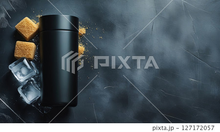 An artistic still life composition featuring a sleek, black thermos surrounded by elements of sugar cubes and ice. 127172057