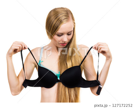 Woman trying on black pushup bra 127172252