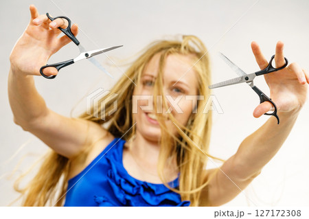 Young woman with scissors for haircutting Young woman with scissors for haircutting 127172308