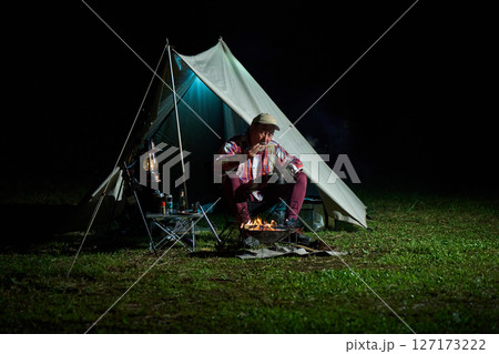 夜食でラーメンを食べるソロキャンパー　ソロキャンプ　シニア 127173222