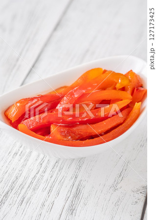 Grilled red bell pepper slices placed in clean white ceramic serving bowl 127173425
