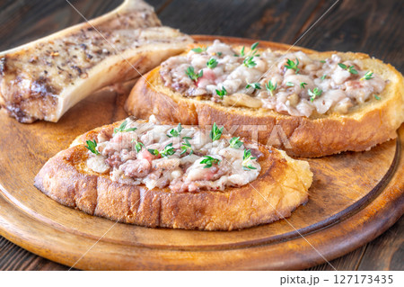 Toasted marrow sandwiches garnished with thyme served on crusty golden bread slices Toasted marrow sandwiches garnished with thyme served on crusty golden bread slices 127173435