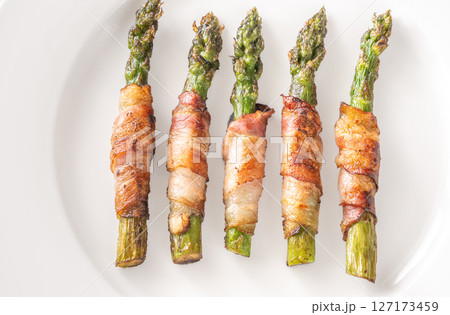 Crispy Fried Asparagus Wrapped In Bacon Served Simply On White Plate 127173459