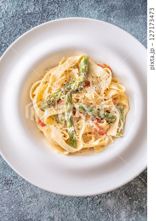 Tagliatelle pasta with creamy garlic sauce, asparagus, peppers, and parmesan topping Tagliatelle pasta with creamy garlic sauce, asparagus, peppers, and parmesan topping 127173473