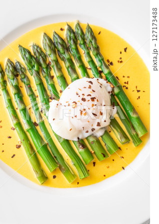 White Plate of Asparagus Nestled in Hollandaise Sauce With Poached Egg 127173488
