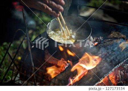 夜食でラーメンを食べるソロキャンパー　ソロキャンプ　シニア 127173534