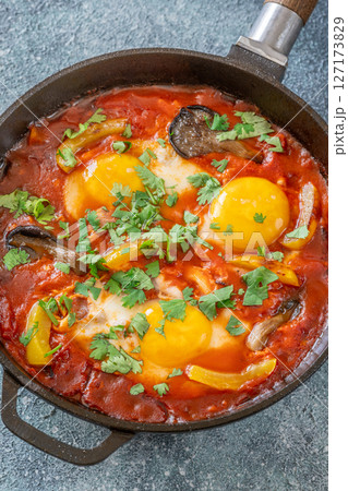 Shakshuka with mushrooms and yellow peppers topped with eggs and cilantro Shakshuka with mushrooms and yellow peppers topped with eggs and cilantro 127173829