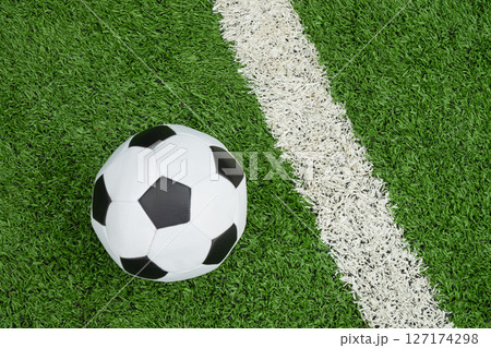 Soccer Ball on Green Grass Field with White Line. Football stadium background. View from above. Soccer Ball on Green Grass Field with White Line. Football stadium background. View from above. 127174298