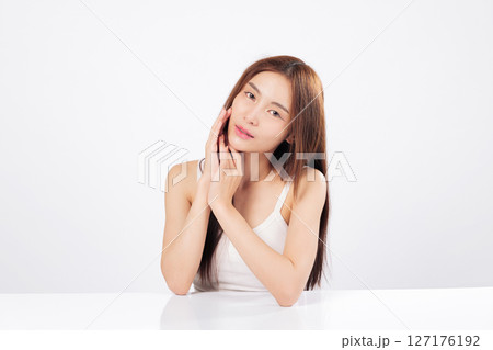 Skin glow and radiant skin define this gentle beauty moment as an Asian woman touches her face with care, promoting skincare, softness, and wellness in portrait style isolated studio white background Skin glow and radiant skin define this gentle beauty moment as an Asian woman touches her face with care, promoting skincare, softness, and wellness in portrait style isolated studio white background 127176192