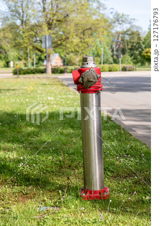Red and Silver Fire Hydrant Installed on Grass Lawn in Urban Public Park Red and Silver Fire Hydrant Installed on Grass Lawn in Urban Public Park 127176793