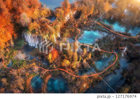 Aerial view of waterfall in red autumn forest at sunrise 127176974