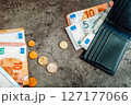 Finance. Money banknotes, coins and black wallet. Euros on dark background 127177066