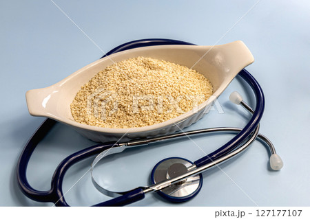 Sesame seeds in a white bowl and stethoscope 127177107