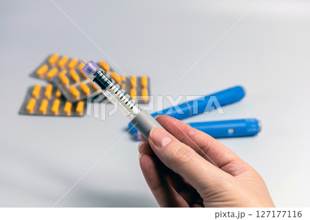 Hand holding Ozempic Insulin injection pen for diabetics and weight loss Hand holding Ozempic Insulin injection pen for diabetics and weight loss 127177116