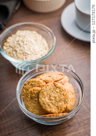 Sweet oatmeal cookies in bowl on wooden table. 127178170