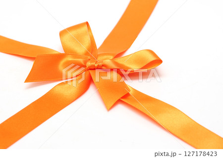 白背景のオレンジ色のリボン 127178423
