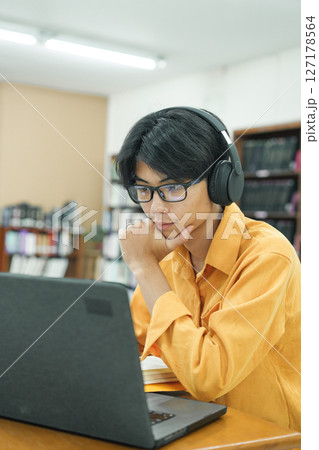 Young collage student using computer and mobile device studying online. Young collage student using computer and mobile device studying online. 127178564