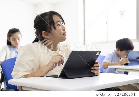 タブレットを使って授業を受ける子ども 127180571