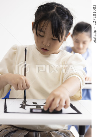 書道をする子どもたち 127181083