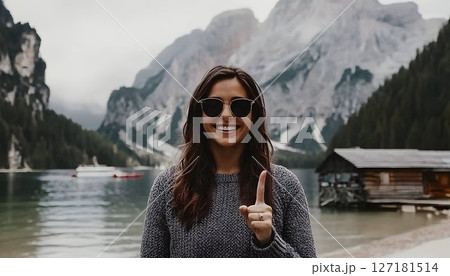Smiling Woman Gesturing Number One by Mountain Lake 127181514