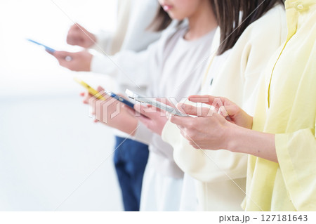 スマートフォンを使う親子の手元 127181643