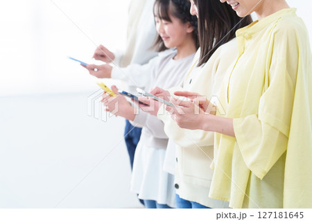 スマートフォンを使う親子の手元 127181645