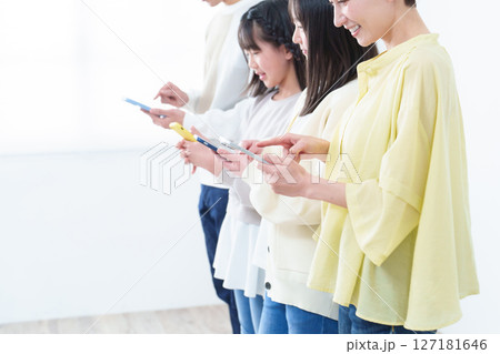 スマートフォンを使う親子の手元 127181646