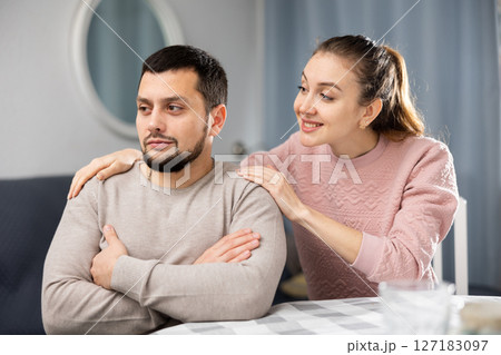 Woman comforting offended husband after spat at home 127183097