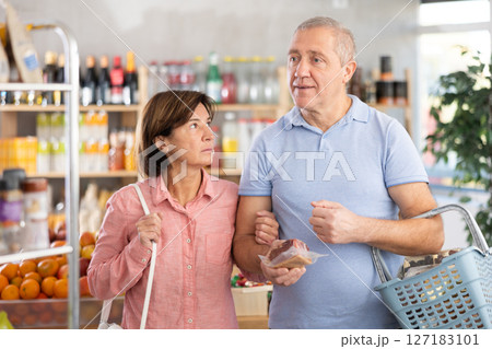 Couple man and woman choosing groceries in store Couple man and woman choosing groceries in store 127183101