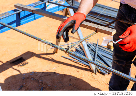 Steel rebar is being secured by worker on construction site under concrete pouring construction Steel rebar is being secured by worker on construction site under concrete pouring construction 127183210