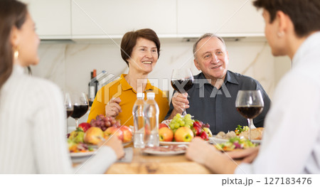 Happy senior parents having dinner with daughter and son-in-law 127183476