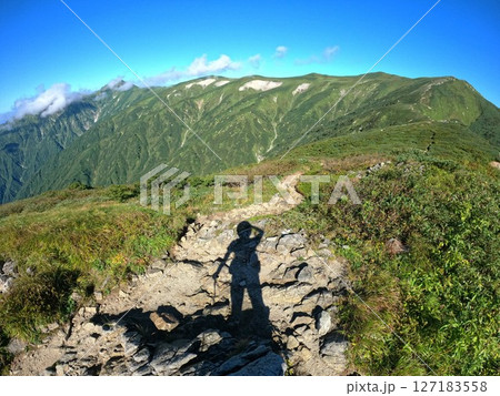 草履塚からの飯豊連峰の主稜線と登山者の影 草履塚からの飯豊連峰の主稜線と登山者の影 127183558