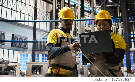 Engineering team doing brainstorming in smart factory, analyzing IoT sensor data. Industry 4.0 plant teamworking colleagues managing operational reliability of photovoltaic systems, camera A Engineering team doing brainstorming in smart factory, analyzing IoT sensor data. Industry 4.0 plant teamworking colleagues managing operational reliability of photovoltaic systems, camera A 127183654