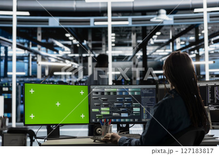 Developer in data center at green screen PC uses AI for machine learning workloads. IT specialist in server hub uses artificial intelligence on chroma key computer to perform demanding computing tasks 127183817