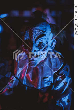Terrifying Halloween Clown with Glowing Eyes in Haunted House Terrifying Halloween Clown with Glowing Eyes in Haunted House 127183818