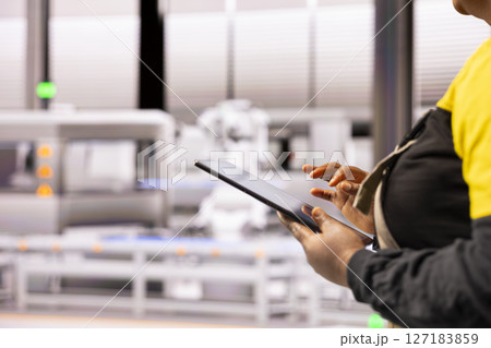 High tech industrial plant specialist programs and refines robot arm automation processes, using digital interface to enhance production efficiency. Professional engineer upgrading industry 4.0 system 127183859