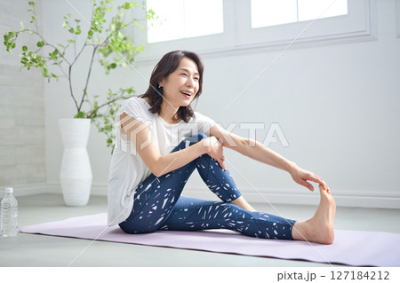 ヨガウェアでヨガをする50代女性 127184212