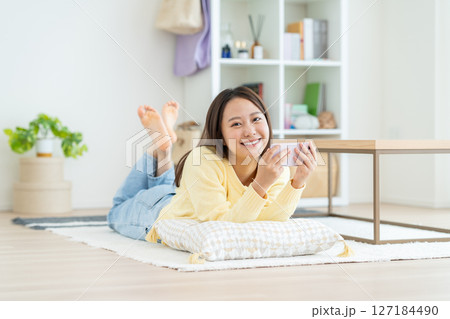 スマホで動画を見る若い女性 スマホで動画を見る若い女性 127184490