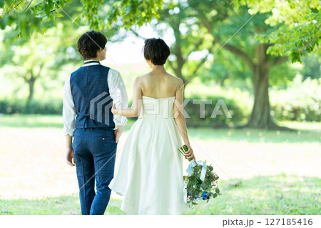 腕を組んで歩く新郎新婦の後ろ姿 127185416