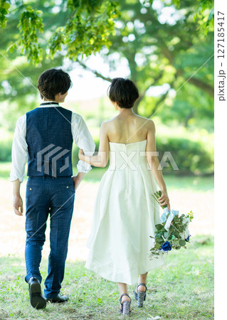 腕を組んで歩く新郎新婦の後ろ姿 127185417