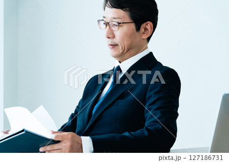 資料をチェックするビジネスマン 127186731