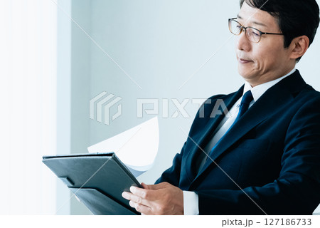 資料をチェックするビジネスマン 127186733