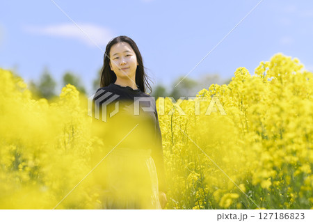 満開の菜の花畑を観光する女性 127186823